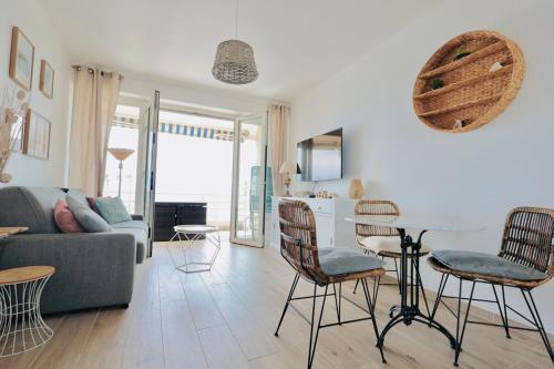 un salon avec un canapé, une table et des chaises dans l'établissement L'impérial - Apt 3 Prs vue mer - Clim - Parking, à Vallauris