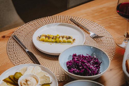 a table with a plate of food and a bowl of red cabbage at Lahnerhof Chalets in Lutago