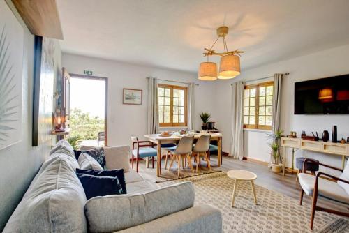 a living room with a couch and a table at The Chestnut Garden - Farm House in Fenais da Luz