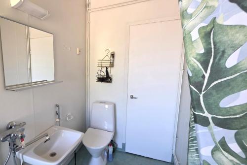 a bathroom with a white toilet and a sink at Villa Ruths Stay Vegas in Kouvola