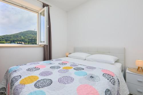 een slaapkamer met een bed en een raam bij Apartment Voyager in Dubrovnik