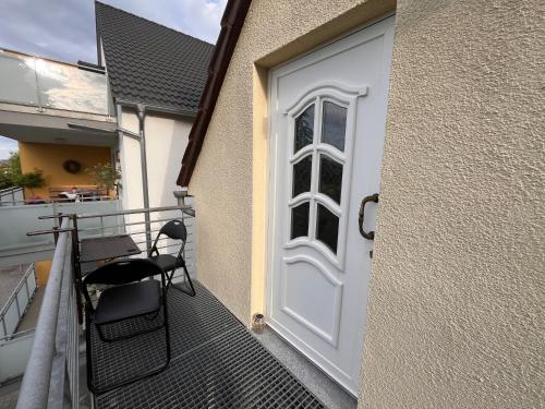 a white door with a table and chairs on a balcony at Dachstub in Brackenheim