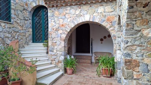 an entrance to a stone building with potted plants at Capocanto Rooms in Camerota