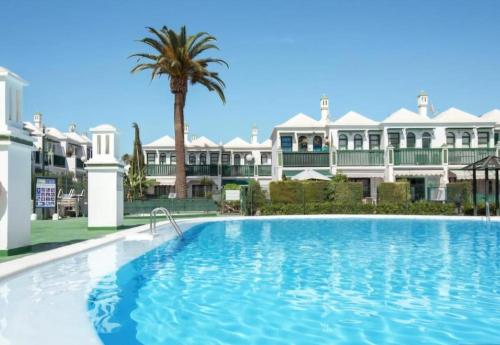 a large swimming pool in front of a large building at Bungalow Faro y Dunas Maspalomas in Maspalomas