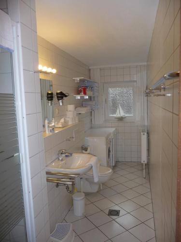 a white bathroom with a sink and a toilet at Wohnung Kattenwarft EG in Böhl