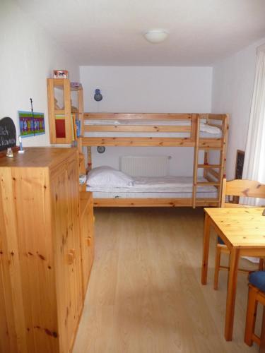 a room with two bunk beds and a table at Wohnung Kattenwarft EG in Böhl