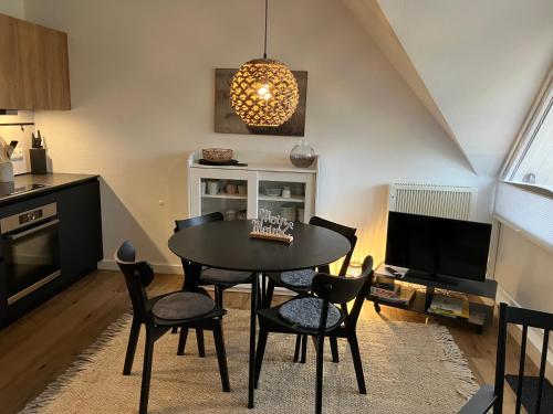 a kitchen with a dining room table and chairs at Wohnung Wanlik Hüs in St. Peter-Ording