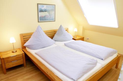 a bedroom with a bed with white sheets and pillows at Haus Schimmelreiter in St. Peter-Ording