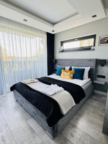 a bedroom with a large bed with blue pillows at Apartamenty BLUE BALTIC SPA Jacuzzi & Sauna MORZE in Chłopy