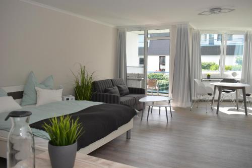 BöhlにあるAppartement Anlage Residenz Nordseeliebe Nr 2のベッドルーム1室、リビングルーム(ベッド1台、ソファ付)