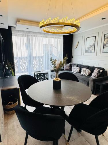 a living room with a table and chairs and a couch at Apartamenty BLUE BALTIC SPA Jacuzzi & Sauna MORZE in Chłopy