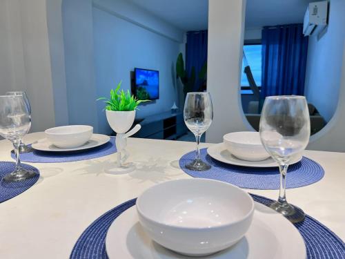 a table with plates and wine glasses on it at Vista al Mar in Caraballeda