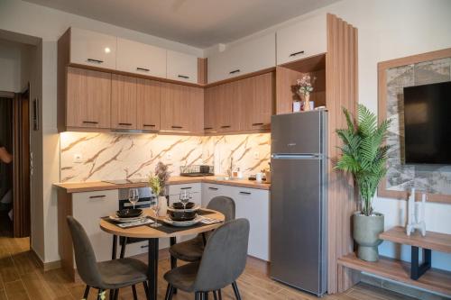 a kitchen with a table and chairs and a refrigerator at Sandy'sLuxuryApartment in Alexandroupoli
