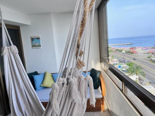 a hanging hammock in a room with a view of the ocean at Vista al Mar in Caraballeda