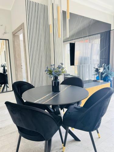 a dining room with a black table and chairs at Apartamenty BLUE BALTIC SPA Jacuzzi & Sauna MORZE in Chłopy