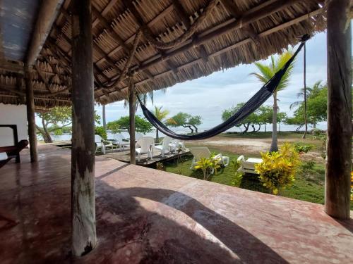 a porch with a hammock and a view of the ocean at Cabaña ecológica frente al mar en isla fuerte in Isla Fuerte