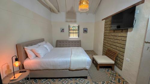 a bedroom with a bed and a flat screen tv at Hotel Casa Amalia in Villa de Leyva