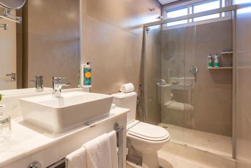 a bathroom with a sink and a toilet and a shower at Sanma Hotel in Foz do Iguaçu