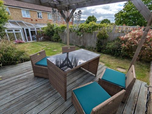 a patio with a table and chairs on a deck at Modern 3B Eastbourne Retreat: Tranquil & Cozy Stay in Eastbourne