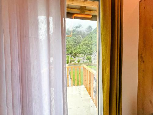 an open window with a view of a balcony at Fryma e Bjeshkeve in Theth