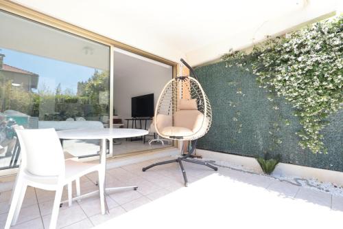 une chambre avec une chaise et une table sur un balcon dans l'établissement Roses des Mers - Apt Standing 2 Prs - Clim - Parking, à Antibes