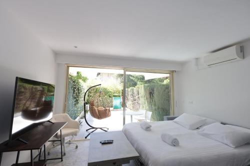 une chambre avec un lit, un bureau et une télévision dans l'établissement Roses des Mers - Apt Standing 2 Prs - Clim - Parking, à Antibes