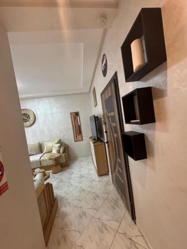 a living room with a couch and a door at Appartement Casablanca près de la mer in Dar Bouazza