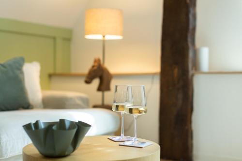 two glasses of wine on a table in a bedroom at Fewo Eickhorst in Menslage