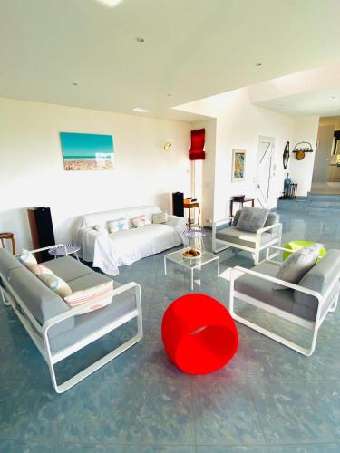 - un salon avec des canapés et un tabouret rouge dans l'établissement Atlantide - Somptueuse Villa Classée 4 étoiles - Saint-Clair - Vue Exceptionnelle - Piscine, à Sète