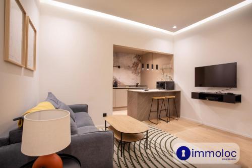 un salon avec un canapé bleu et une cuisine dans l'établissement Air-conditioned apartment in Old Nice, à Nice