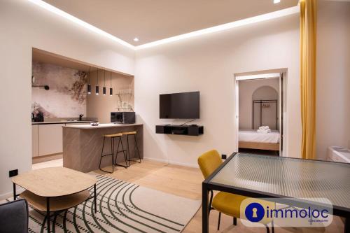 un salon avec une table et une cuisine dans l'établissement Air-conditioned apartment in Old Nice, à Nice