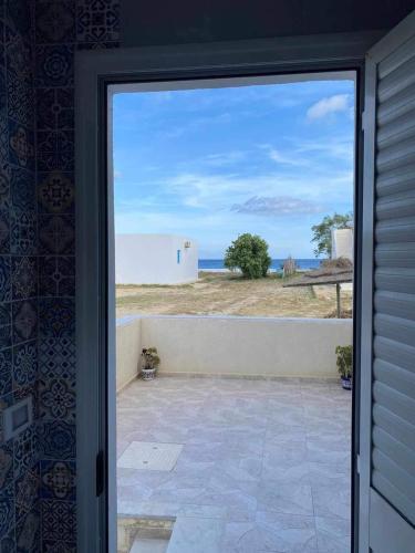 una porta su un patio con vista sull'oceano di Ain grenz2 kelibia a Kelibia