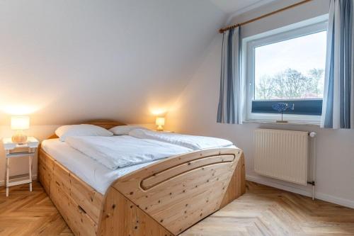 a bedroom with a wooden bed with a window at Haus Eismöwe in Böhl