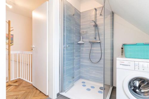a bathroom with a shower and a washing machine at Haus Eismöwe in Böhl