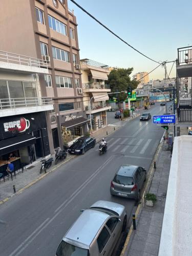 a street with cars parked on the side of the road at Hotspot Acharnes in Akharnaí