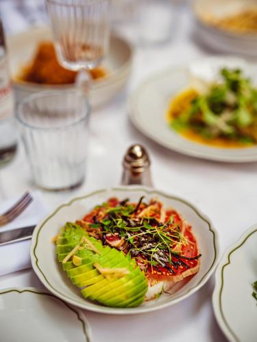 a plate of food on a table with plates of food at Hôtel Eldorado Paris in Paris
