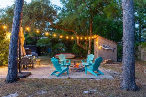 a patio with chairs and a fire pit with lights at Modern Oak Island Escape 1 Mile to Long Beach! in Oak Island
