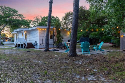 a mobile home with a patio and trees at Modern Oak Island Escape 1 Mile to Long Beach! in Oak Island