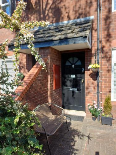a brick building with a bench in front of a door at Cental Retreat - 2 bedroom apartment in Belfast