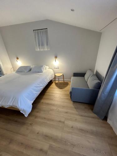 a bedroom with a large bed and a couch at Pensión do Catro in Puebla de Trives