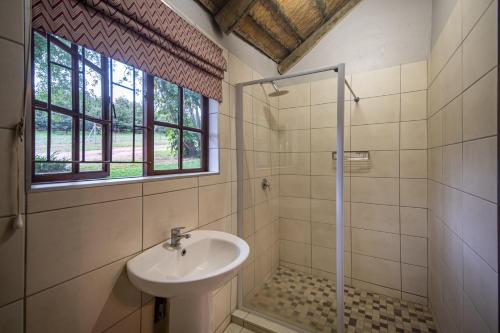 a bathroom with a sink and a shower at Ons Plek Accommodation in Hazyview