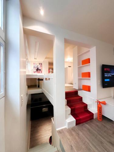 - un escalier dans une maison dotée d'un tapis rouge dans l'établissement Avenue Montaigne, à Paris