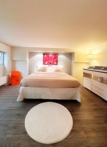 - une chambre avec un grand lit et un tapis blanc dans l'établissement Avenue Montaigne, à Paris