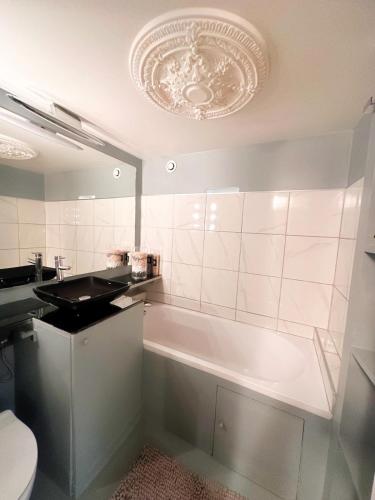 une salle de bain avec une baignoire, un lavabo et des toilettes dans l'établissement Avenue Montaigne, à Paris