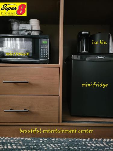 a microwave and a mini fridge next to a dresser at Super 8 by Wyndham Perham in Perham