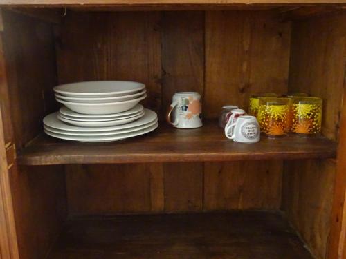 a wooden shelf with plates and cups on it at Camera D'Ambra in Campiglia Marittima