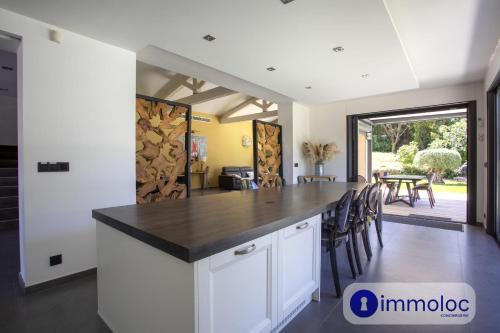 a kitchen with white cabinets and a black counter top at Air-conditioned villa with pool and garden in Mandelieu-la-Napoule