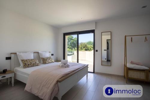 a bedroom with a large bed and a large window at Air-conditioned villa with pool and garden in Mandelieu-la-Napoule
