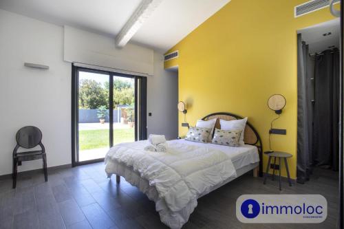 a bedroom with a bed and a yellow wall at Air-conditioned villa with pool and garden in Mandelieu-la-Napoule