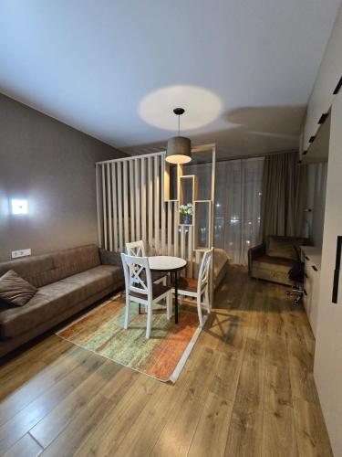 a living room with a table and chairs and a couch at Luxury Suites White Sails in Batumi